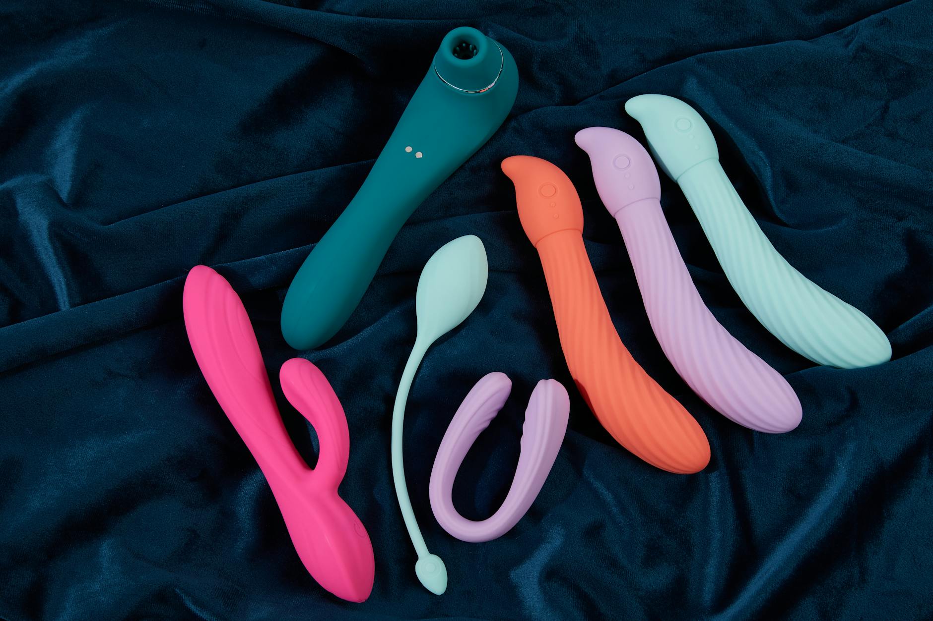 Colorful lemon vibrators and clitoral toys displayed on dark fabric