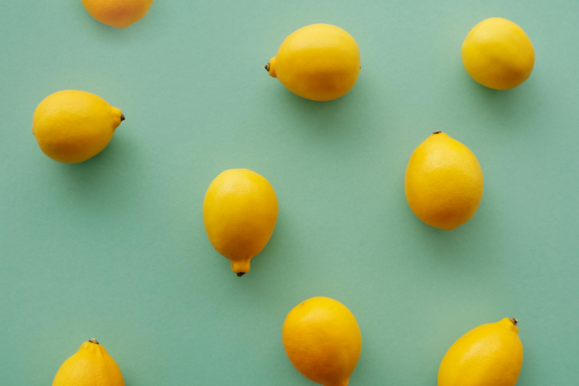 Bright yellow lemons arranged on a pastel green background, symbolizing fresh approaches to pleasure and intimacy.