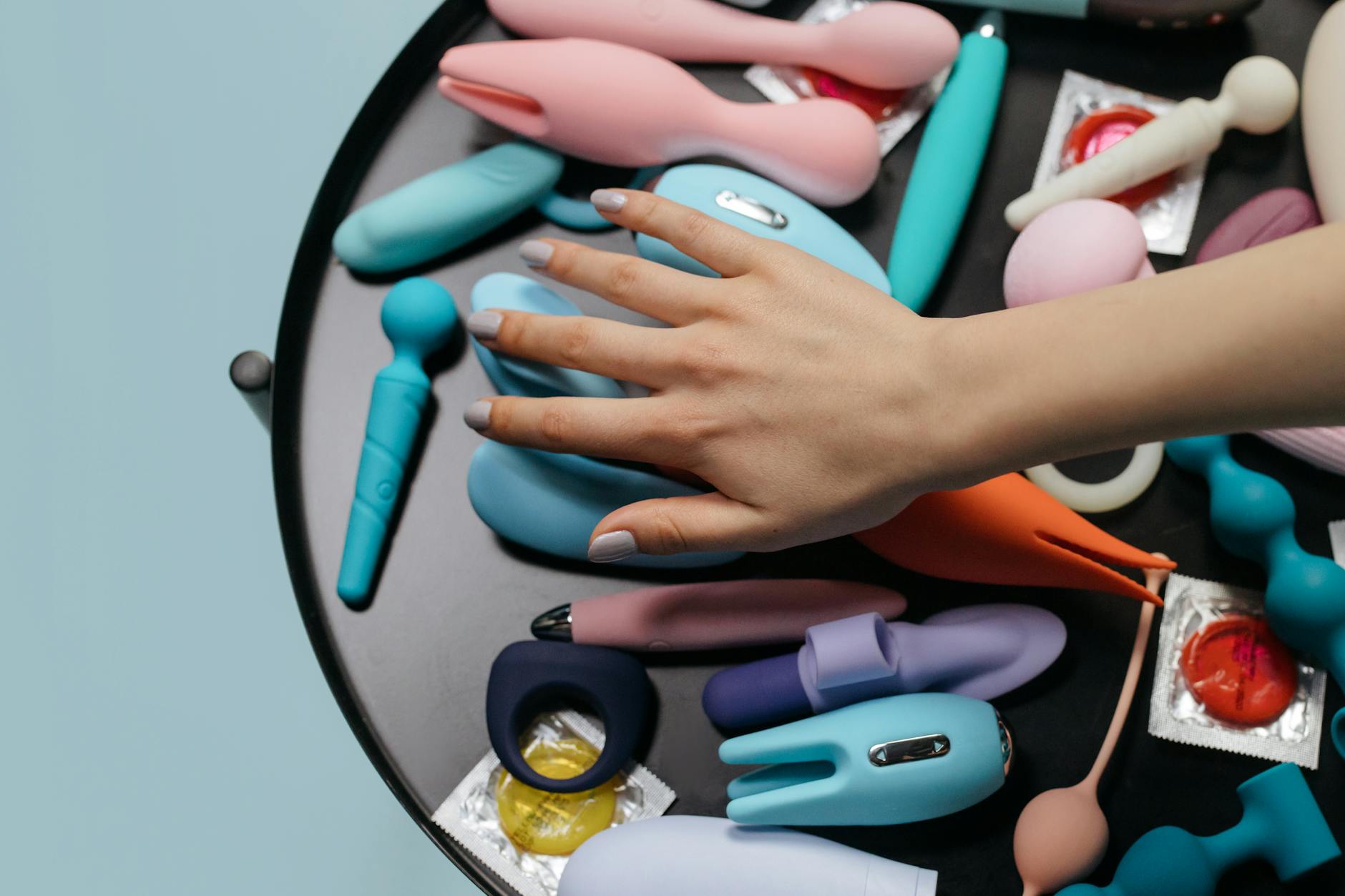 Hands holding a blue lemon vibrator against a knitted sweater.
