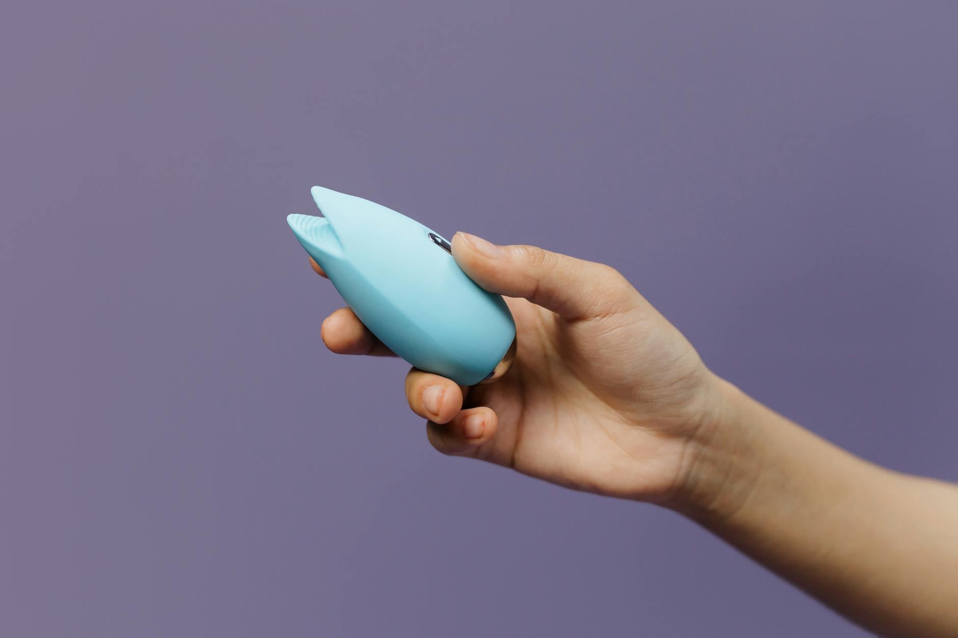 Hands holding a silicone vibrator, representing reconnection and self-care in long-term relationships