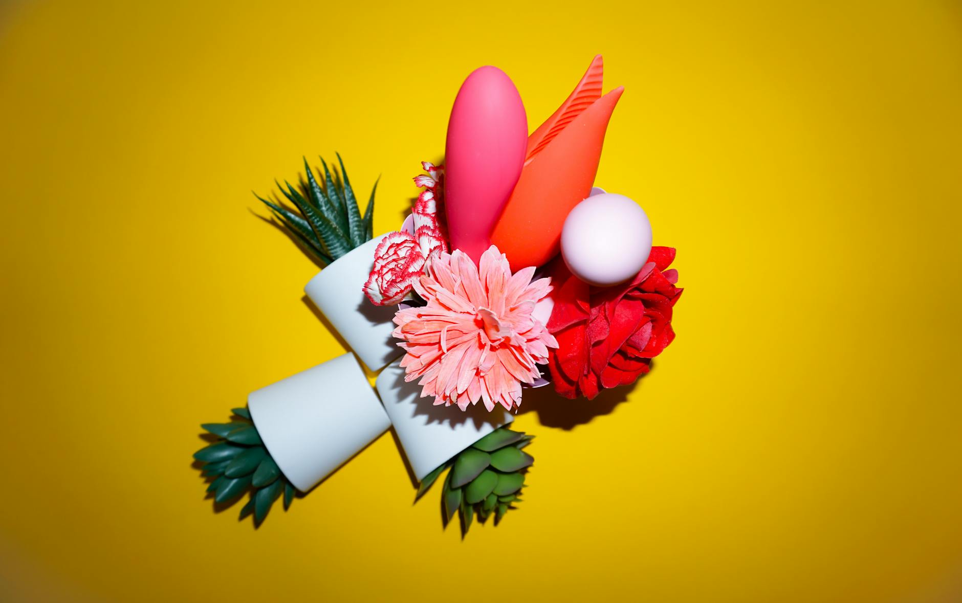 Hands holding pastel-colored silicone vibrators