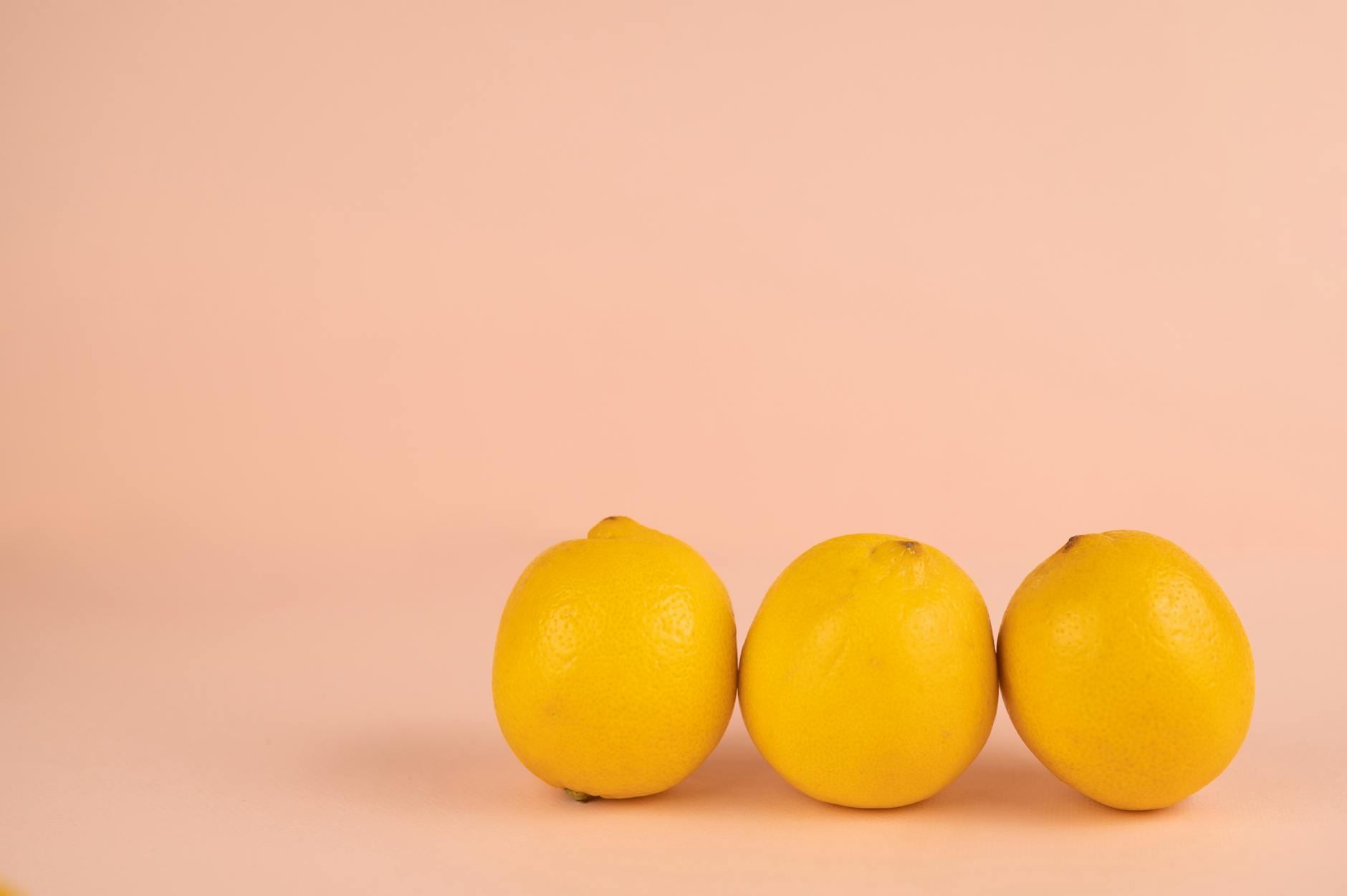 Yellow silicone vibrator surrounded by fresh fruit on a bright background